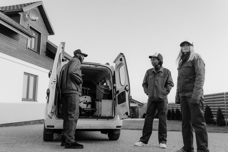 Delmar Brothers crew loading equipment from the service van outside a house